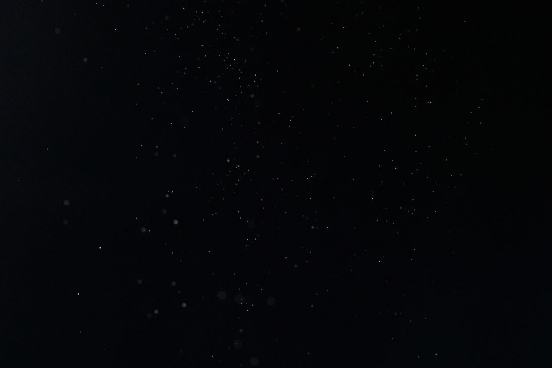 Tiny White Dust Particles on Black Background